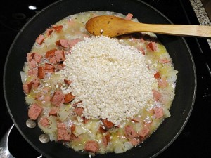 Adding the rice to the sausage risotto recipe