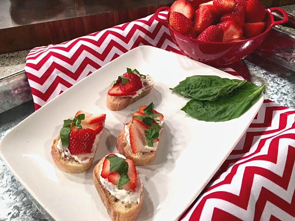 This strawberry crostini appetizer is topped with crispy bacon, fresh basil, cream cheese and strawberries. Perfect for a summer party! Get the recipe on basilmomma.com