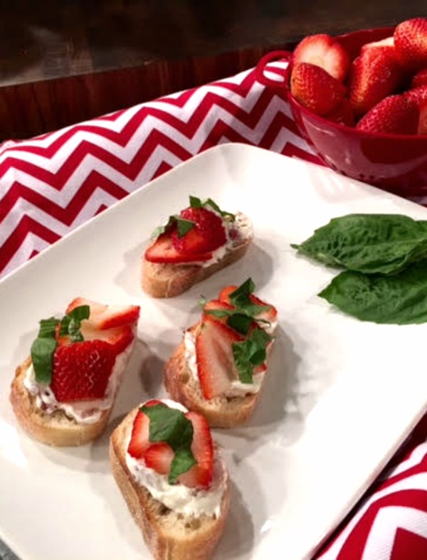 This strawberry crostini appetizer is topped with crispy bacon, fresh basil, cream cheese and strawberries. Perfect for a summer party! Get the recipe on basilmomma.com