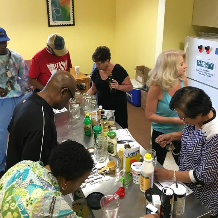 Clients at the Little Red Door Cancer Agency make Mason jar salad dressings in a Door to Wellness workshop.