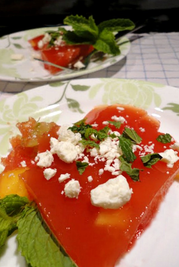 Watermelon Jello salad with feta and mint is a delicious summer side salad recipe. Fresh fruit is added to homemade watermelon Jello and then topped with fresh mint and feta cheese. This watermelon Jello salad recipe makes a perfect light dessert, too.